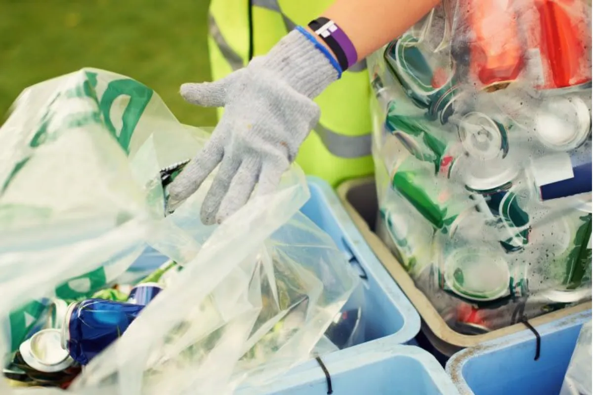 A pile of soda cans on the trash bins