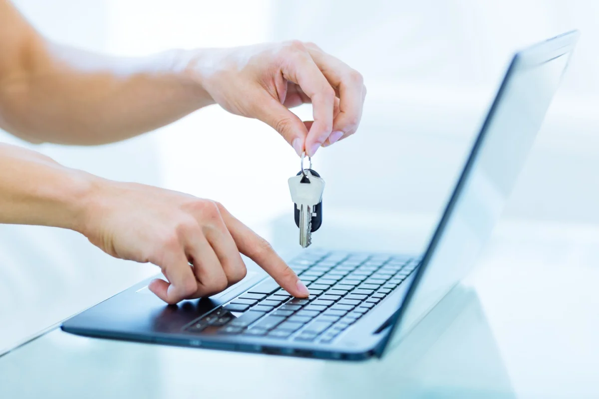Close-up of male hands holding house keys. Real estate purchase, new home ownership.