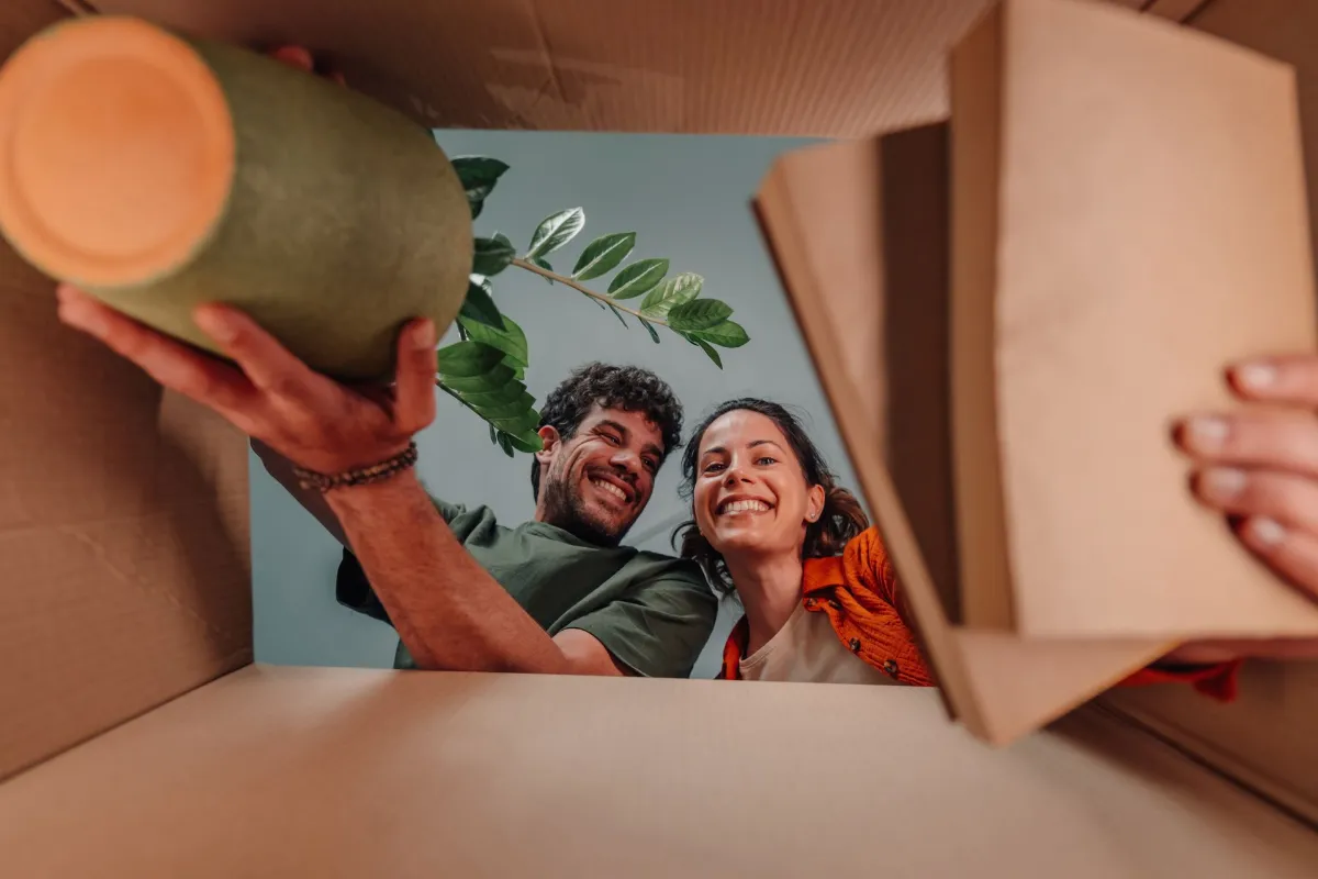 ASSM - Good strata governance and quality residents Young couple smiling unpacking belongings cardboard