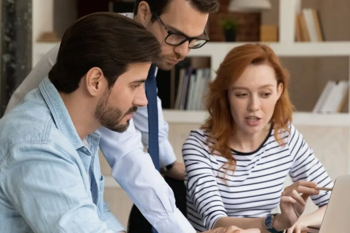 Colleagues busy discussing using laptop
